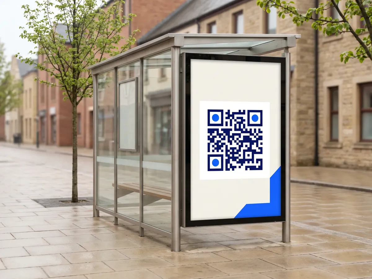 Poster with a large QR code in a bus stop shelter, seen from a few steps away